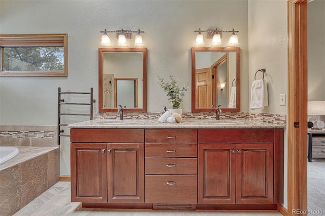 full bathroom featuring double vanity, a bath, and a sink