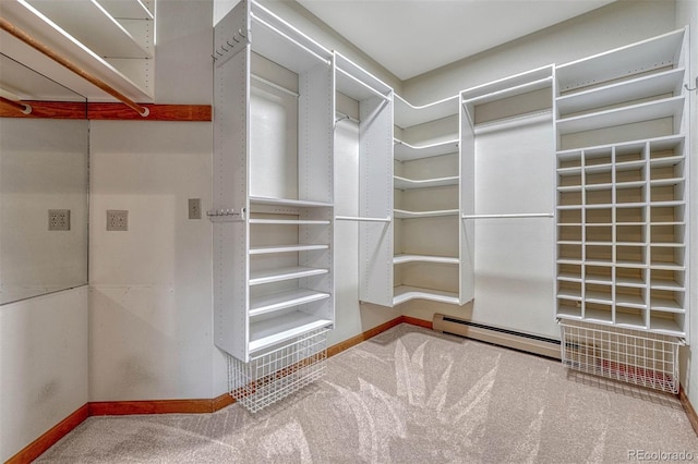 spacious closet featuring a baseboard heating unit and carpet floors