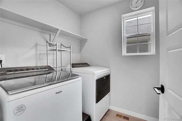 laundry room featuring hardwood / wood-style floors and washer and clothes dryer