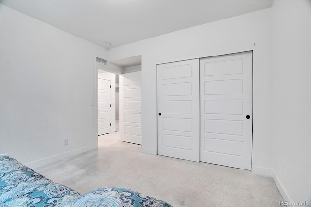 unfurnished bedroom with a closet and light carpet