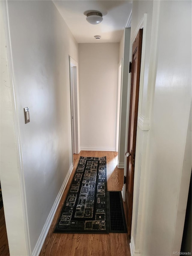 corridor with dark hardwood / wood-style flooring