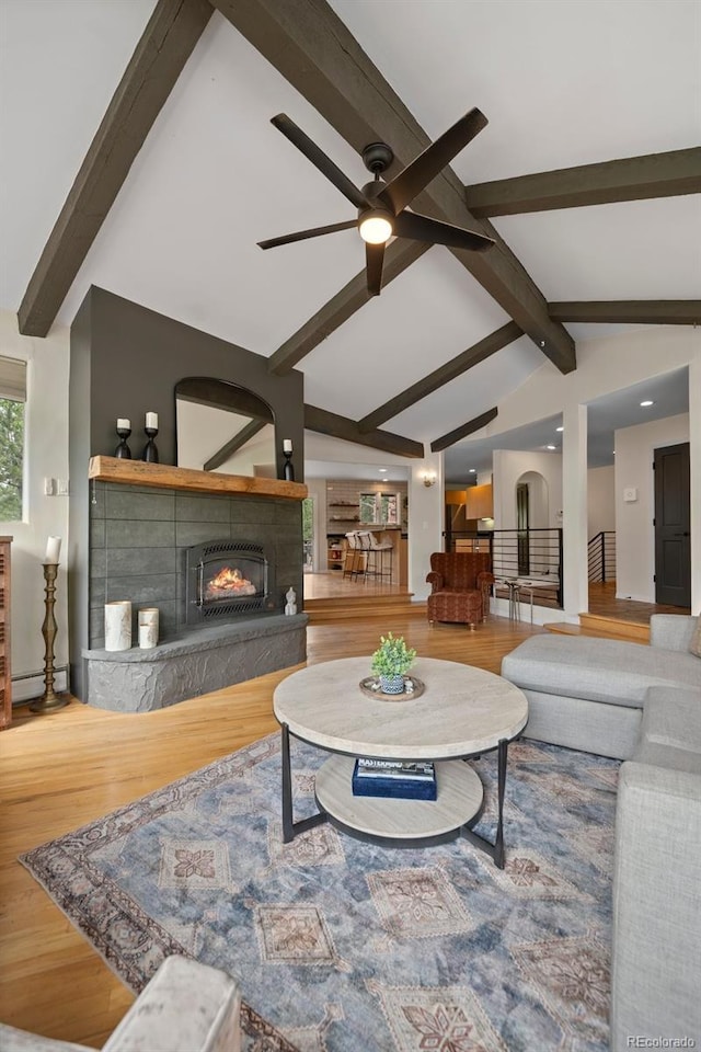 29663 Paint Brush Dr, Evergreen, CO 80439 - living room with ceiling fan, wood finished floors, a lit fireplace, and baseboard heating
