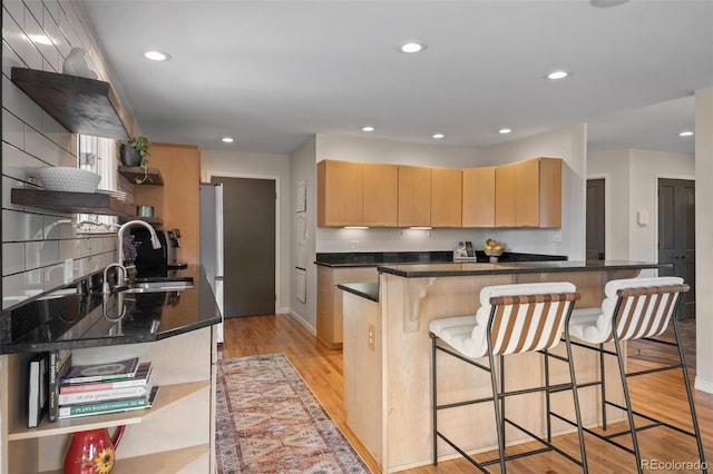 29663 Paint Brush Dr, Evergreen, CO 80439 - kitchen featuring open shelves, a sink, light brown cabinetry, a breakfast bar area, and recessed lighting