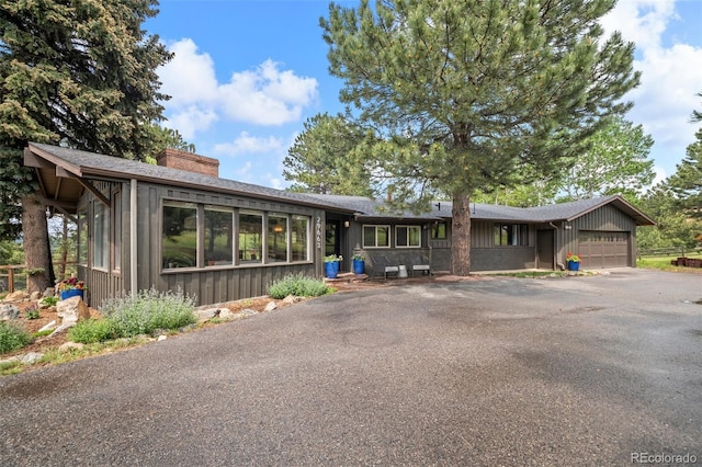 29663 Paint Brush Dr, Evergreen, CO 80439 - single story home with a garage, a chimney, and driveway