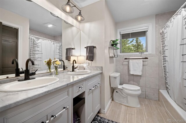29663 Paint Brush Dr, Evergreen, CO 80439 - full bath with double vanity, toilet, tile patterned floors, shower / bath combo with shower curtain, and tile walls