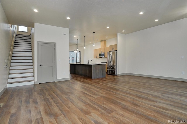 6450 Cleora Rd Unit C, Salida, CO 81201 - kitchen featuring appliances with stainless steel finishes, open floor plan, light countertops, dark wood-style floors, and an island with sink