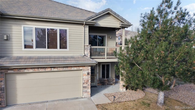 view of front of house featuring a garage and a balcony