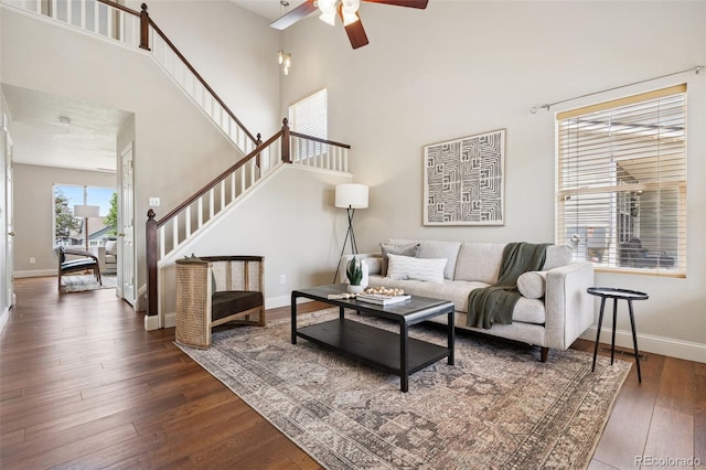 9579 Bighorn Way, Littleton, CO 80125 - living area with a ceiling fan, a towering ceiling, dark wood-style flooring, and stairway