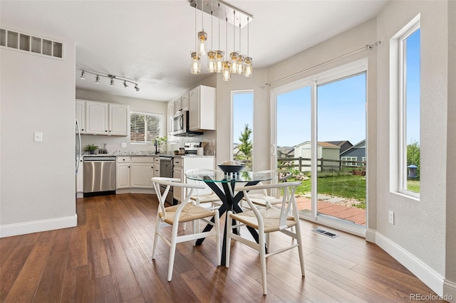 9579 Bighorn Way, Littleton, CO 80125 - dining area with dark wood-style floors and a chandelier