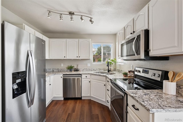 9579 Bighorn Way, Littleton, CO 80125 - kitchen featuring stainless steel appliances, dark wood-type flooring, white cabinets, light stone counters, and a textured ceiling