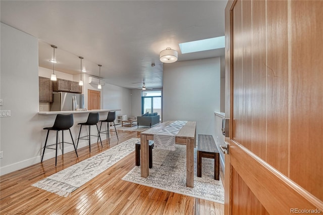 112 Old Stage Rd Unit D, Salida, CO 81201 - dining space with light wood finished floors, a skylight, a ceiling fan, and baseboards