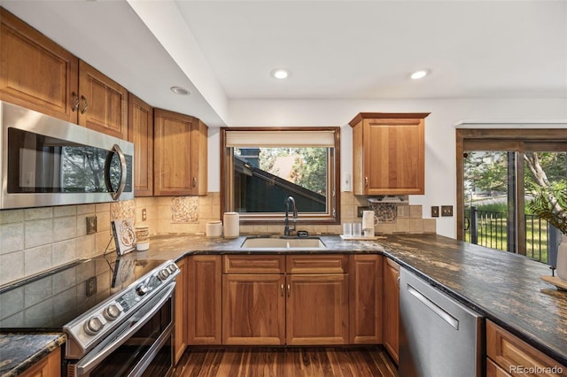 6207 Elbert Pl, Parker, CO 80134 - kitchen with appliances with stainless steel finishes, plenty of natural light, dark wood-style flooring, brown cabinets, and recessed lighting
