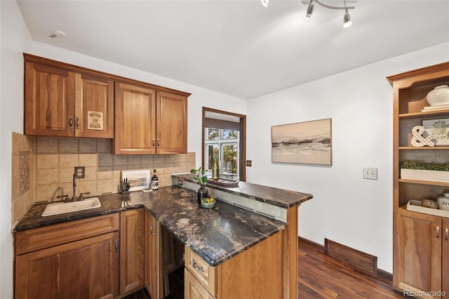 6207 Elbert Pl, Parker, CO 80134 - kitchen with a peninsula, dark wood-style flooring, decorative backsplash, and dark stone counters
