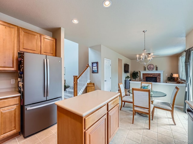 21220 E Nassau Ave, Aurora, CO 80013 - kitchen featuring freestanding refrigerator, open floor plan, a chandelier, light tile patterned floors, and a fireplace