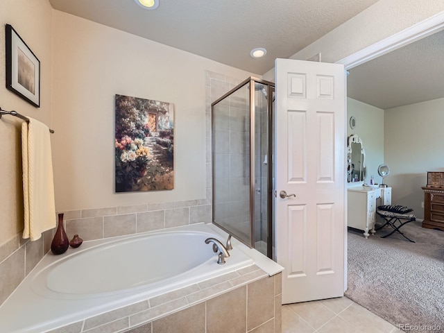 21220 E Nassau Ave, Aurora, CO 80013 - bathroom featuring a garden tub, vanity, a stall shower, a textured ceiling, and tile patterned flooring