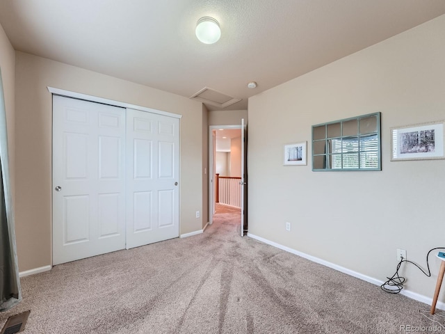 21220 E Nassau Ave, Aurora, CO 80013 - unfurnished bedroom with attic access, carpet flooring, and a closet