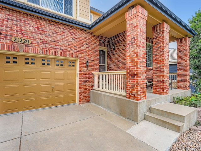 21220 E Nassau Ave, Aurora, CO 80013 - entrance to property featuring brick siding, a porch, a garage, and concrete driveway