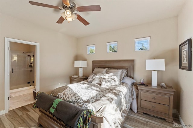 bedroom featuring light hardwood / wood-style floors, ceiling fan, and ensuite bathroom