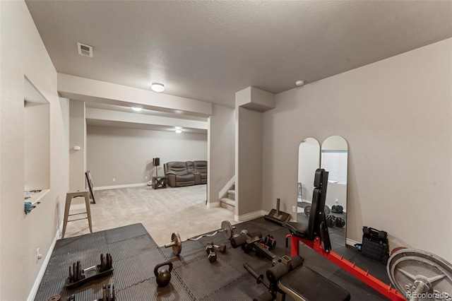 workout area with a textured ceiling and carpet floors