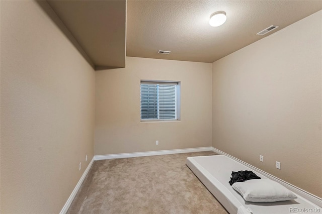 carpeted spare room with a textured ceiling