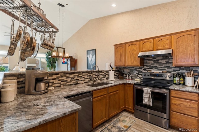 kitchen with hanging light fixtures, decorative backsplash, vaulted ceiling, stainless steel appliances, and sink