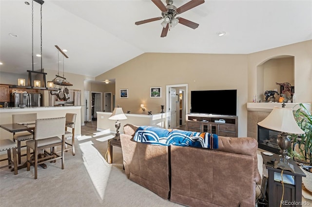 living room featuring lofted ceiling, ceiling fan, and light carpet