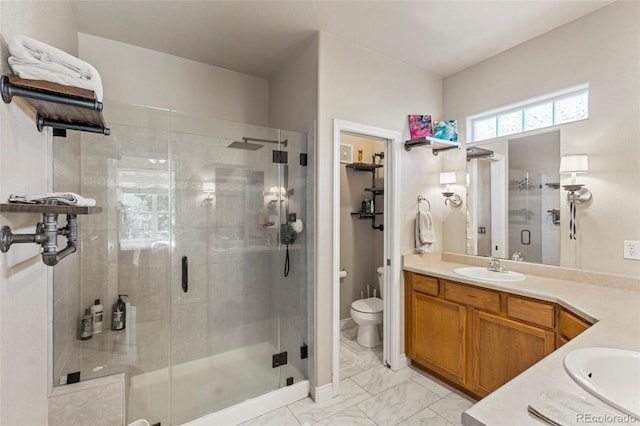 bathroom featuring vanity, toilet, and a shower with door