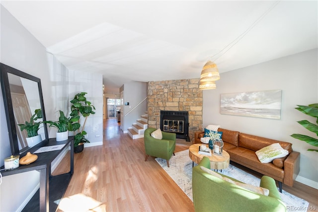 living room featuring light hardwood / wood-style floors, lofted ceiling, and a fireplace