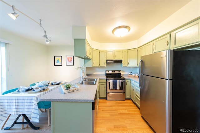 kitchen featuring sink, light wood-type flooring, kitchen peninsula, rail lighting, and stainless steel appliances