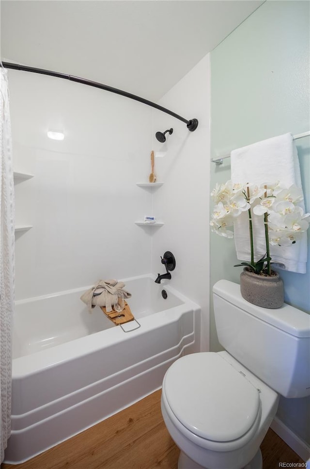 bathroom featuring toilet, hardwood / wood-style floors, and shower / tub combo with curtain