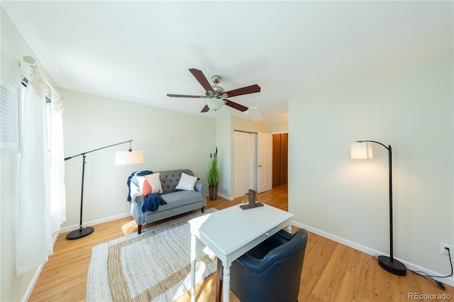 living room with light hardwood / wood-style floors and ceiling fan