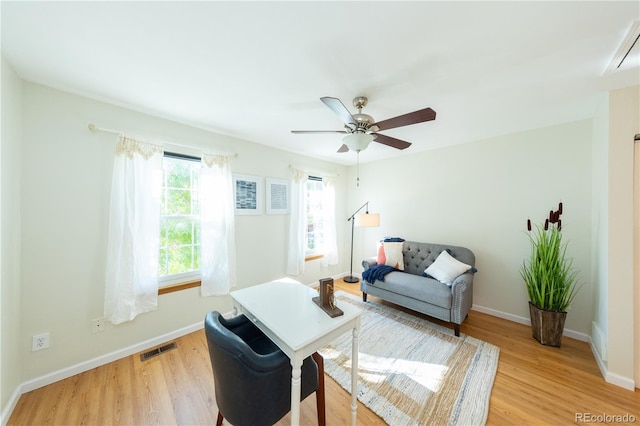 living room with light hardwood / wood-style flooring and ceiling fan