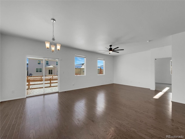 unfurnished living room with ceiling fan with notable chandelier and dark hardwood / wood-style floors