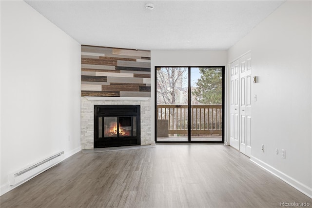 14720 E Kentucky Dr Unit 622, Aurora, CO 80012 - unfurnished living room featuring a baseboard heating unit, wood finished floors, baseboards, and a fireplace