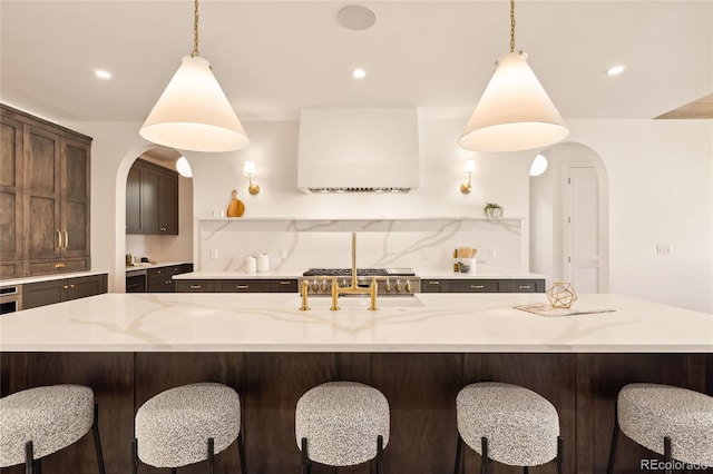 kitchen with a kitchen breakfast bar, a spacious island, and hanging light fixtures