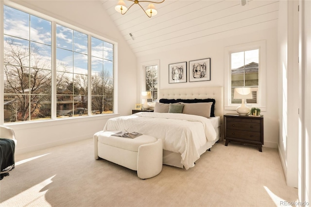 bedroom with light carpet, vaulted ceiling, multiple windows, and a notable chandelier