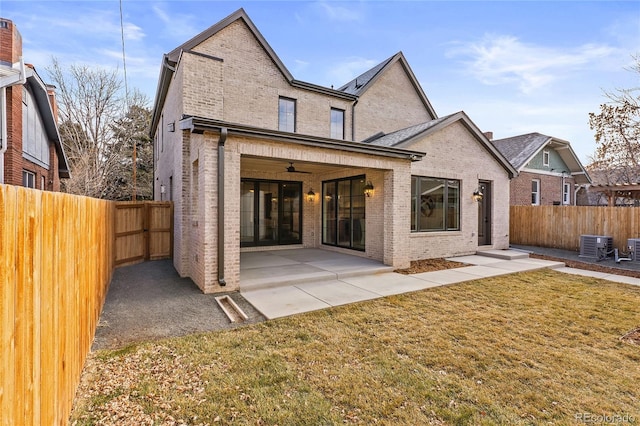 back of property featuring a lawn, a patio area, ceiling fan, and cooling unit