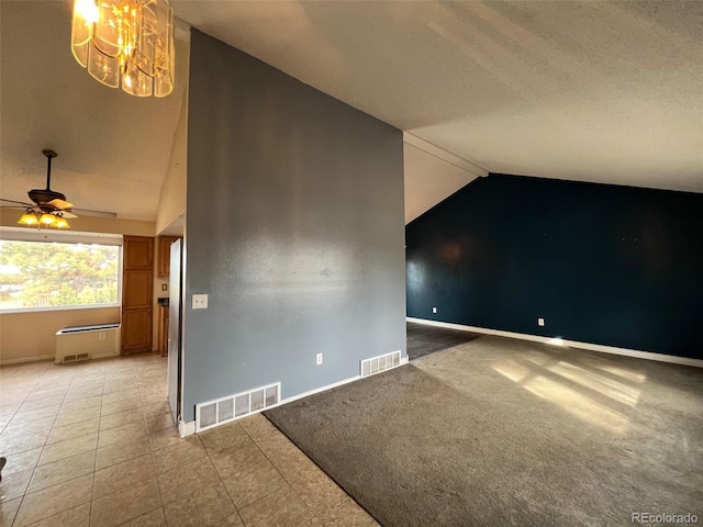 spare room with lofted ceiling, ceiling fan with notable chandelier, and light tile flooring