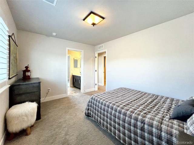 bedroom featuring light colored carpet and ensuite bath