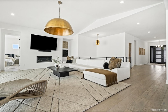 living room featuring hardwood / wood-style flooring and vaulted ceiling