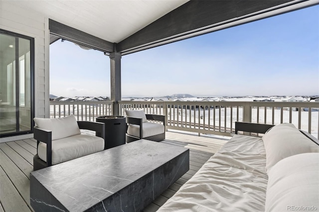 snow covered deck featuring a mountain view and an outdoor hangout area