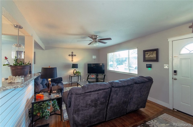 living room with dark wood-type flooring, a wealth of natural light, and ceiling fan