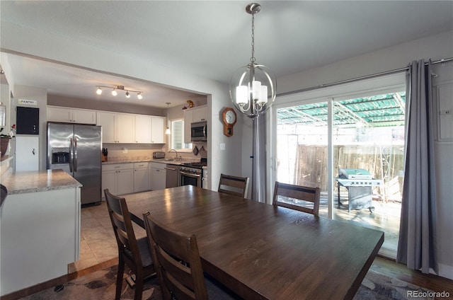 tiled dining area featuring sink and an inviting chandelier