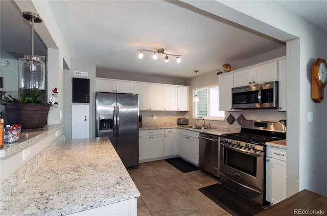 kitchen with stainless steel appliances, white cabinetry, hanging light fixtures, and sink