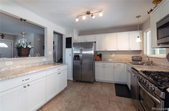 kitchen featuring decorative light fixtures, stainless steel appliances, and white cabinets