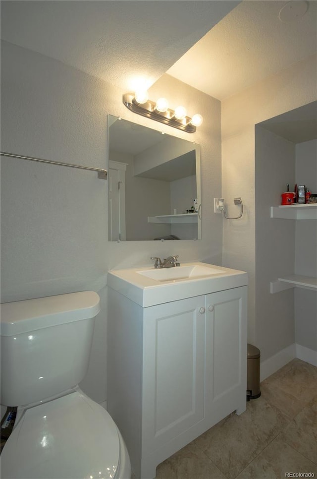 bathroom with vanity, tile patterned flooring, and toilet