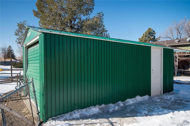 snow covered structure featuring a garage