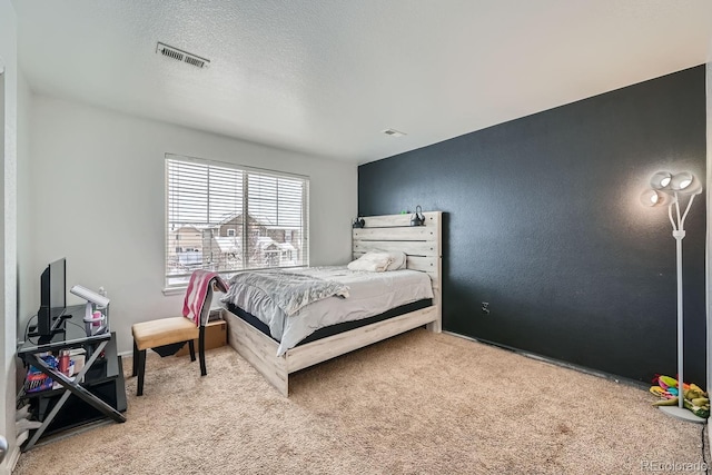 carpeted bedroom featuring a textured ceiling