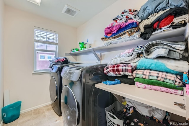 laundry room featuring light tile patterned floors and washing machine and clothes dryer