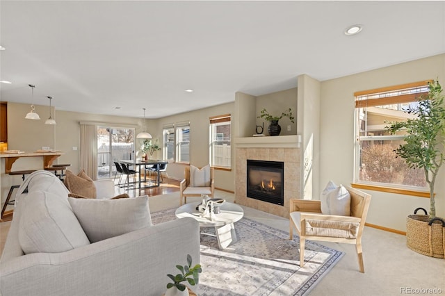 living room featuring a tiled fireplace and light carpet